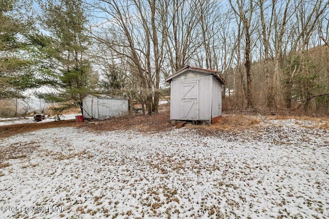 snow covered structure with a storage unit and an outdoor structure