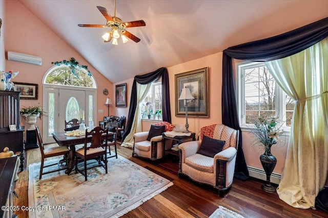 sitting room featuring baseboard heating, a wealth of natural light, and wood finished floors