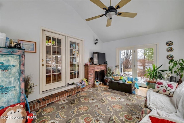 living room featuring a brick fireplace, vaulted ceiling, and ceiling fan