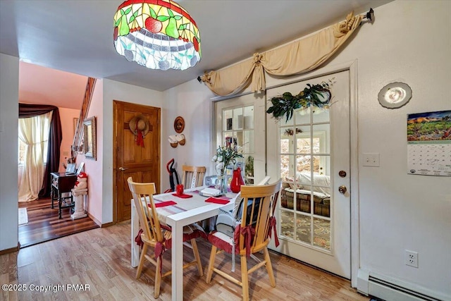 dining area with light wood-style flooring and baseboard heating