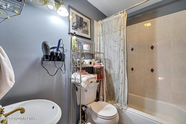 full bathroom with shower / bath combination with curtain, a sink, and toilet