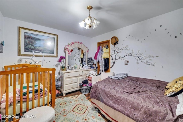 bedroom with a notable chandelier and wood finished floors