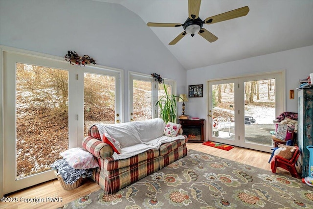 living area featuring high vaulted ceiling, plenty of natural light, wood finished floors, and a ceiling fan