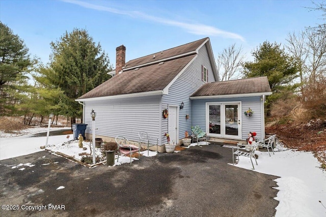 back of property with a patio area, driveway, and a chimney