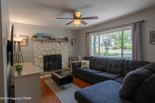 living room featuring a fireplace, wood finished floors, and a ceiling fan