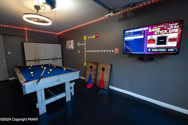 game room with baseboards and an AC wall unit