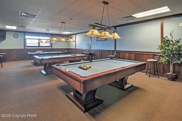 rec room with carpet floors, wood walls, visible vents, and wainscoting