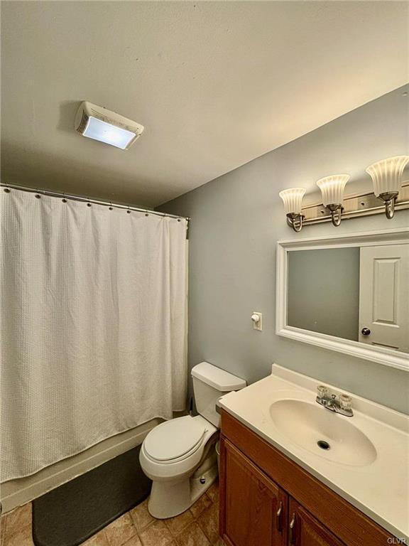 full bath with vanity, toilet, and shower / bath combo with shower curtain