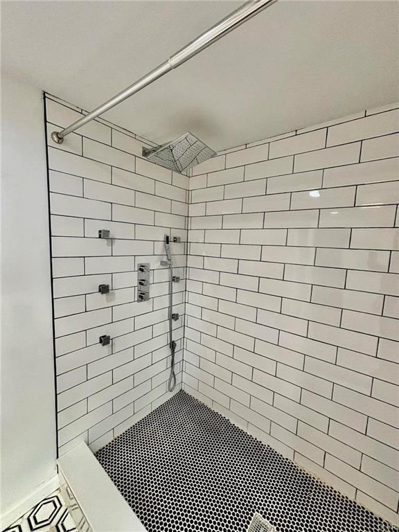 full bathroom featuring tiled shower