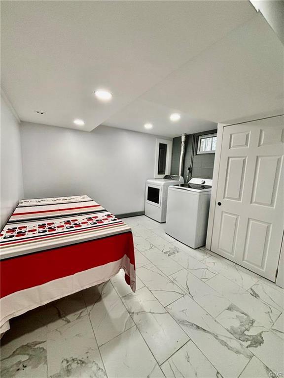 bedroom with independent washer and dryer, recessed lighting, and marble finish floor