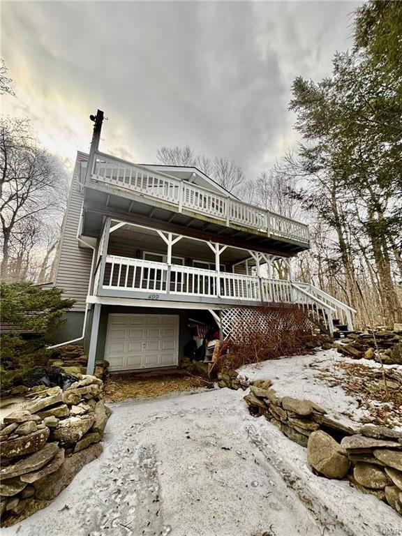 view of front of home featuring stairway, an attached garage, and driveway