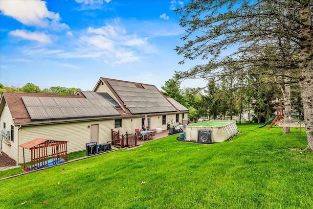 225 Northpark Dr W, East Stroudsburg, PA 18302 - back of property featuring roof mounted solar panels, a playground, a pool, and a yard