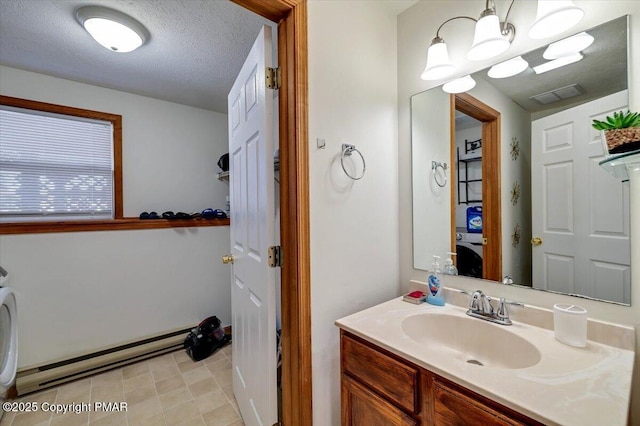 bathroom featuring visible vents, a baseboard heating unit, vanity, a textured ceiling, and a chandelier