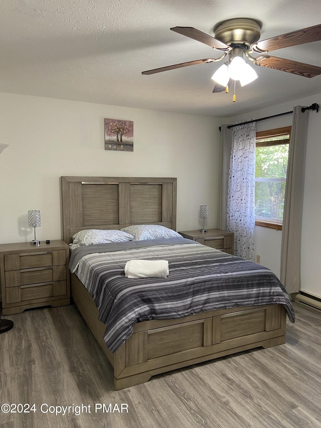 bedroom featuring a textured ceiling, wood finished floors, and a ceiling fan