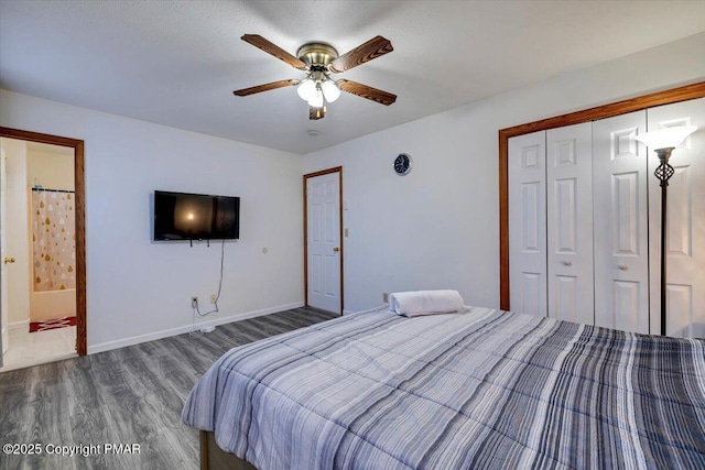 bedroom featuring ceiling fan, wood finished floors, baseboards, a closet, and ensuite bath