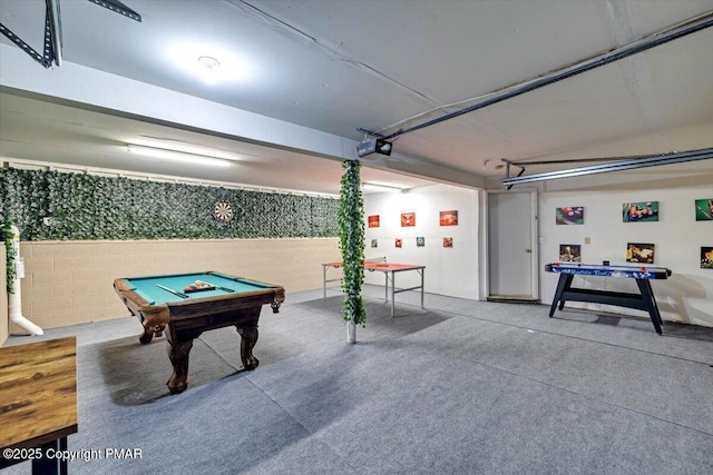 recreation room featuring a garage, concrete block wall, concrete floors, and pool table