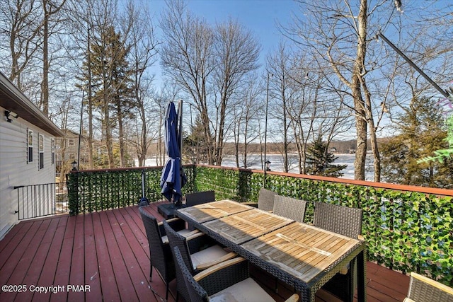 deck featuring outdoor dining area and a water view