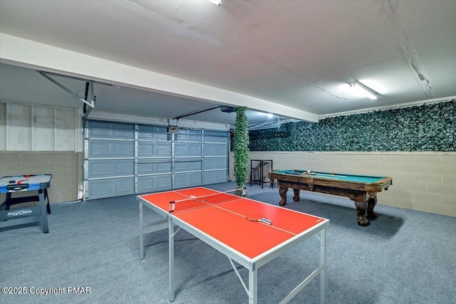 game room with concrete block wall, billiards, and a garage