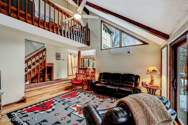 living area with baseboards, beamed ceiling, stairs, wood finished floors, and a wall mounted AC