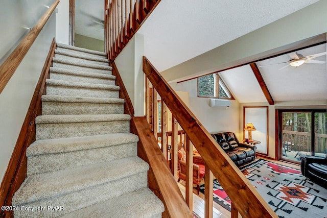 stairway with a ceiling fan, vaulted ceiling with beams, and wood finished floors