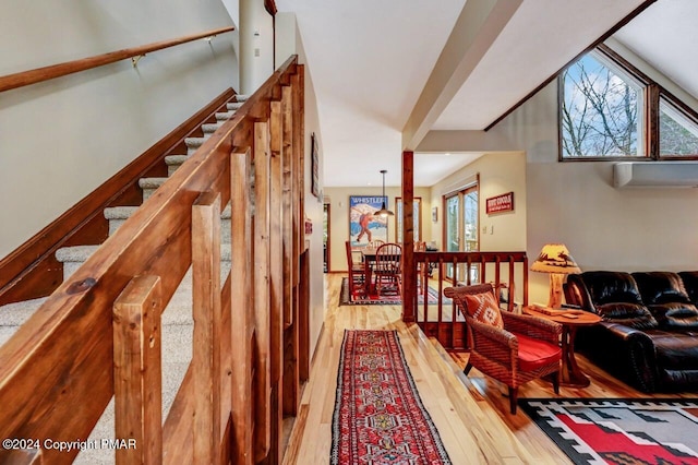 stairway featuring a wall mounted AC and wood-type flooring