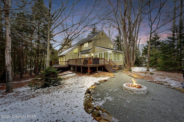 rear view of property featuring a deck and an outdoor fire pit