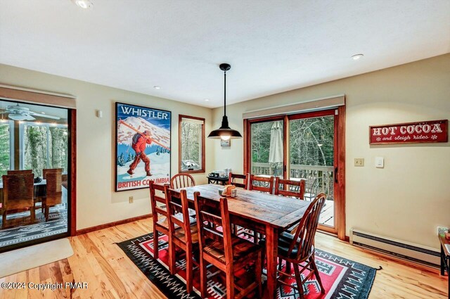 dining space with light wood-style floors, baseboards, and baseboard heating