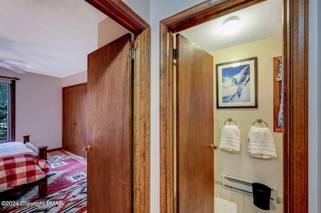 hallway featuring a textured ceiling and baseboards