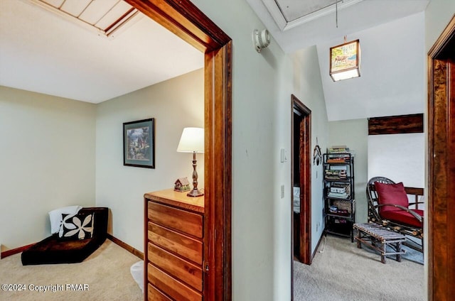 hallway featuring baseboards, attic access, and carpet flooring