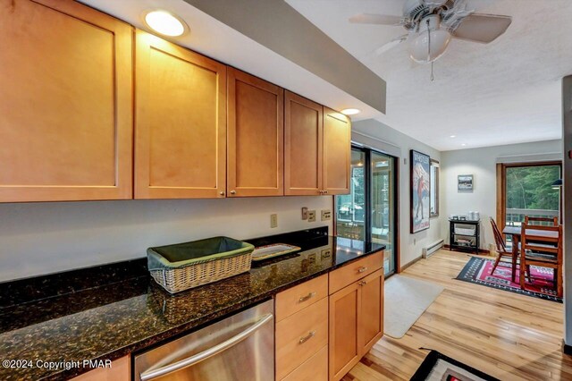 kitchen featuring light wood finished floors, dark stone counters, ceiling fan, dishwasher, and a baseboard heating unit