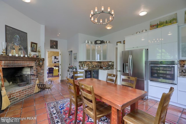 tiled dining room with a brick fireplace and a chandelier