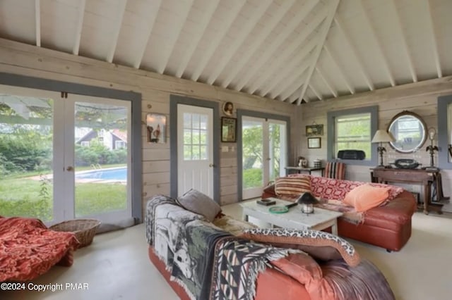 living room featuring lofted ceiling with beams, carpet flooring, and wooden walls