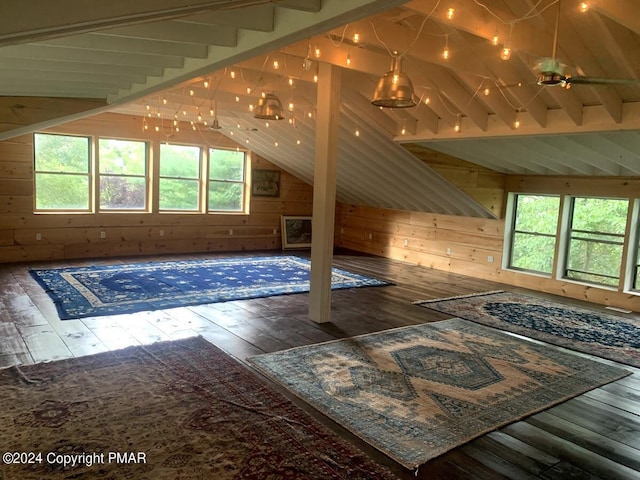 bonus room featuring vaulted ceiling with beams, wood walls, and hardwood / wood-style floors