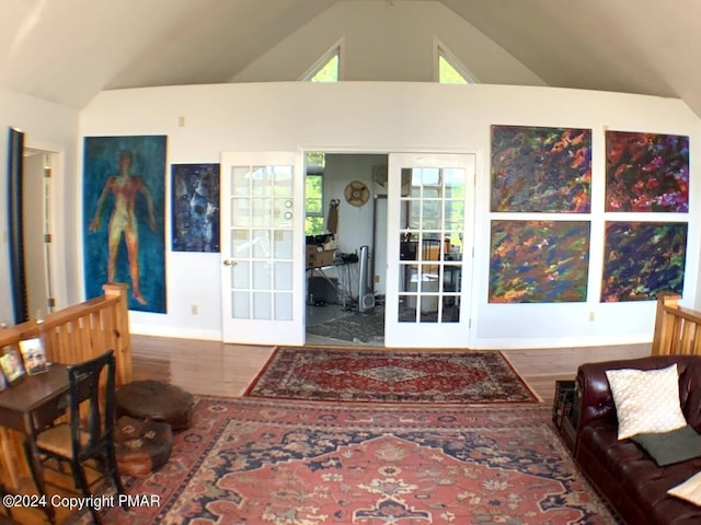 interior space with vaulted ceiling, french doors, wood finished floors, and baseboards