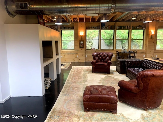 living area featuring visible vents and wooden walls