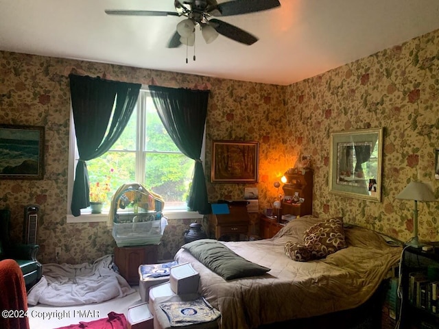 bedroom featuring a ceiling fan and wallpapered walls