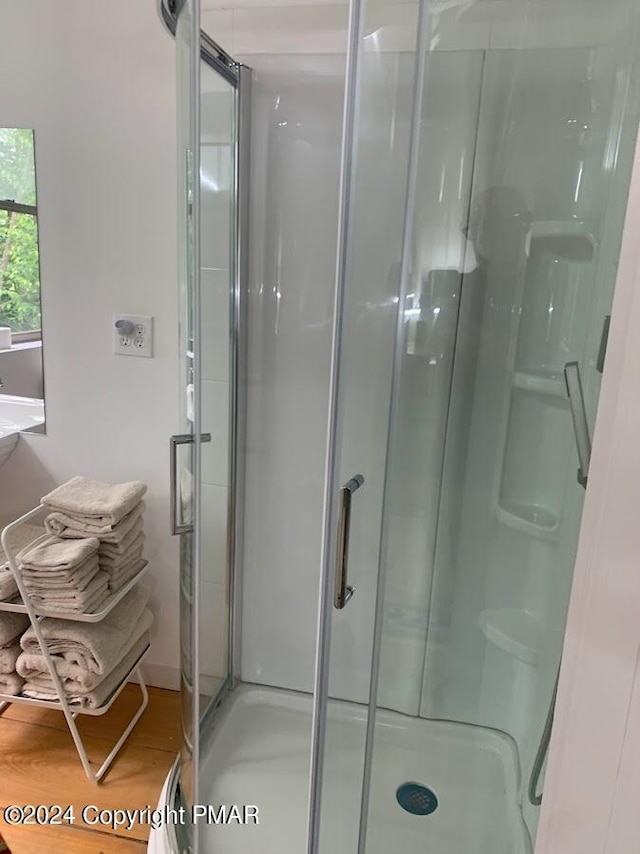 bathroom featuring a stall shower and wood finished floors