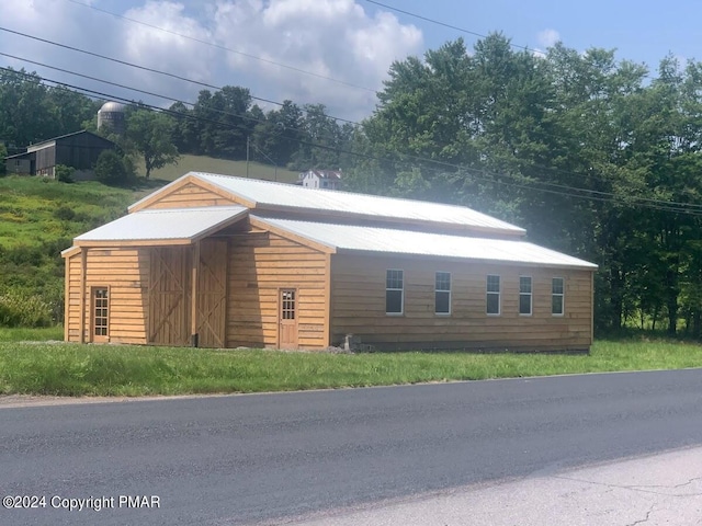 view of front of property with an outbuilding and metal roof