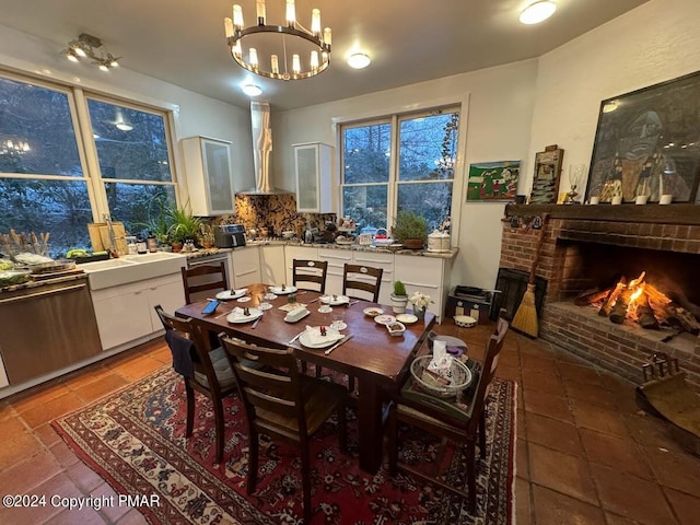 dining area featuring wine cooler, a brick fireplace, light tile patterned flooring, and an inviting chandelier