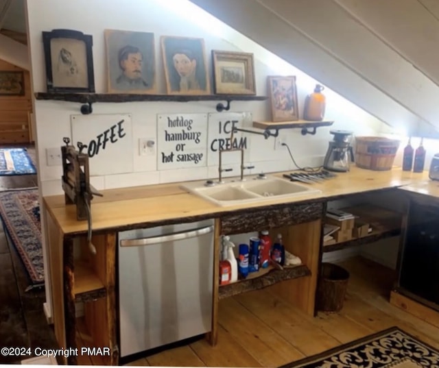 bar with dishwasher, vaulted ceiling, wood-type flooring, and a sink