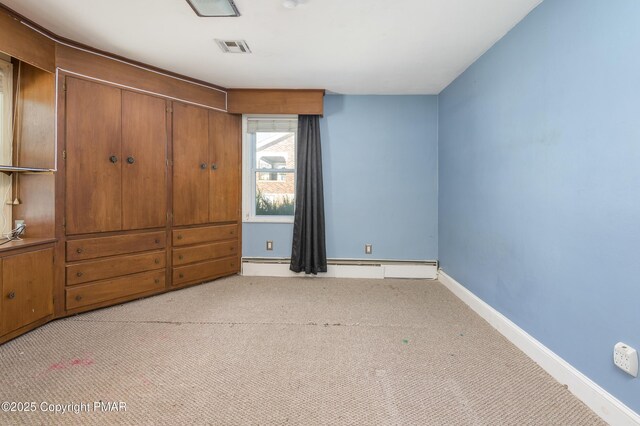 unfurnished bedroom featuring baseboard heating and light carpet