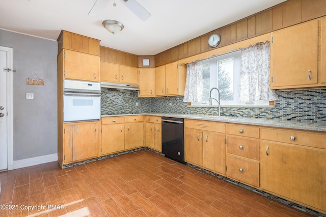 kitchen featuring black dishwasher, sink, white oven, and backsplash