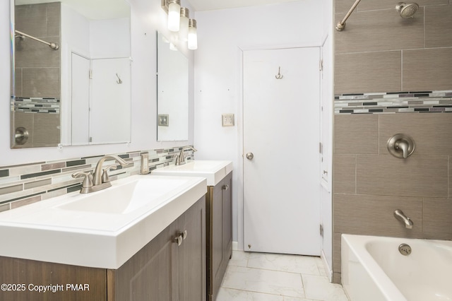 bathroom with tasteful backsplash, tiled shower / bath, and vanity