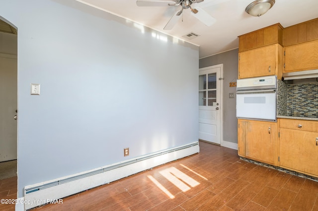 kitchen featuring tasteful backsplash, a baseboard radiator, wood-type flooring, oven, and ceiling fan