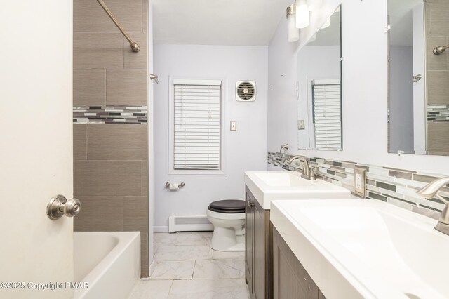 full bathroom featuring toilet, tasteful backsplash, tiled shower / bath, baseboard heating, and vanity