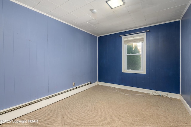 carpeted spare room with ornamental molding and a baseboard heating unit