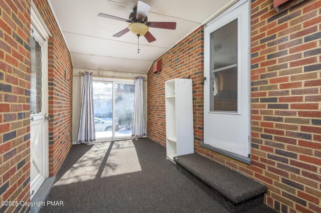 unfurnished sunroom featuring ceiling fan