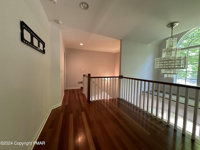 hallway with a notable chandelier, recessed lighting, wood finished floors, and baseboards