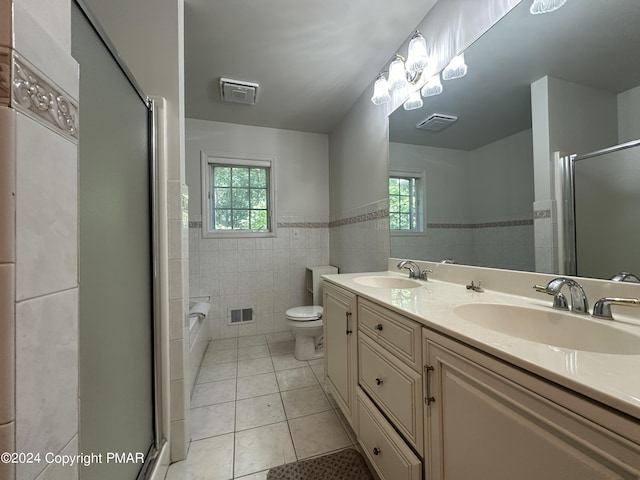 full bath with an enclosed shower, tile walls, a sink, and tile patterned floors