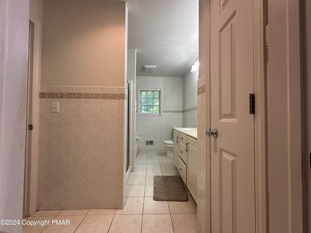 full bathroom featuring visible vents, toilet, tile patterned flooring, vanity, and tile walls